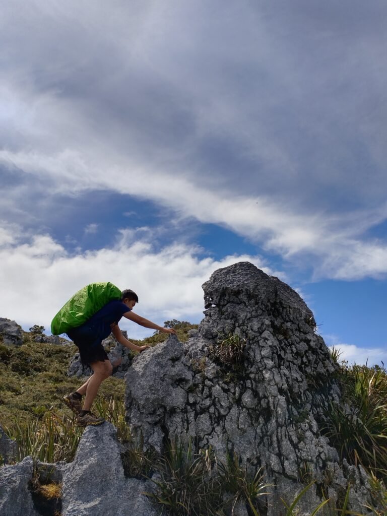 Mt Kampalili Maragusan Davao de Oro hiker climbing a limestone rock summiting the peak.