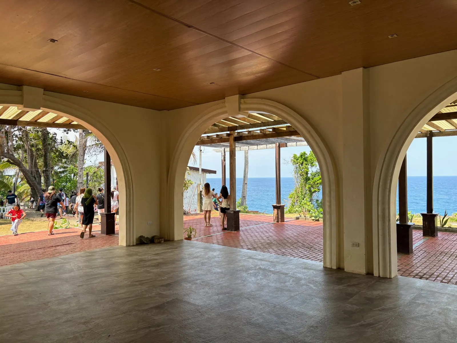 Covered arched pavilion at Cape San Agustin Parola with a brick patio and a view of the blue ocean